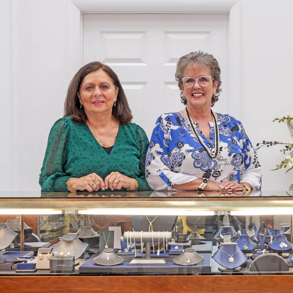Two women by jewelry case Two women by jewelry case