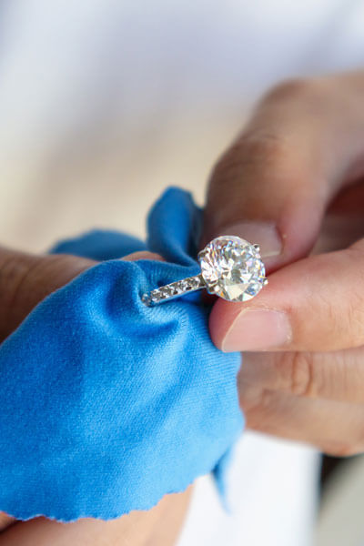 Jeweller Hand Polishing And Cleaning Jewelry Diamond Ring With M