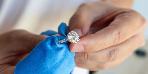 Jeweller Hand Polishing And Cleaning Jewelry Diamond Ring With M